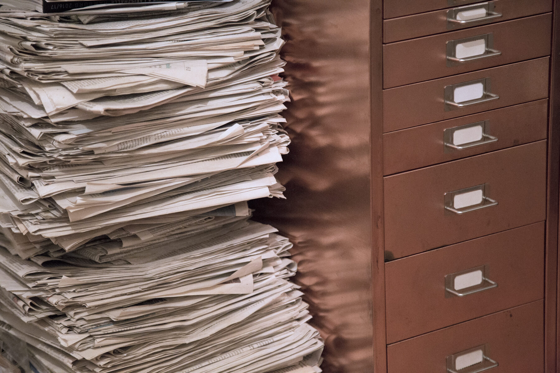 Gestapelte Abzüge neben einem Registerschrank